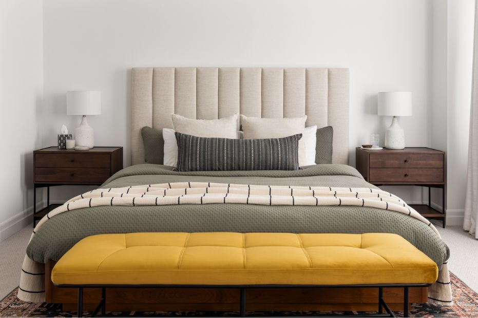 Colourful Primary Bedroom Large bed with upholstered headboard, wood nightstands, and velvet bench